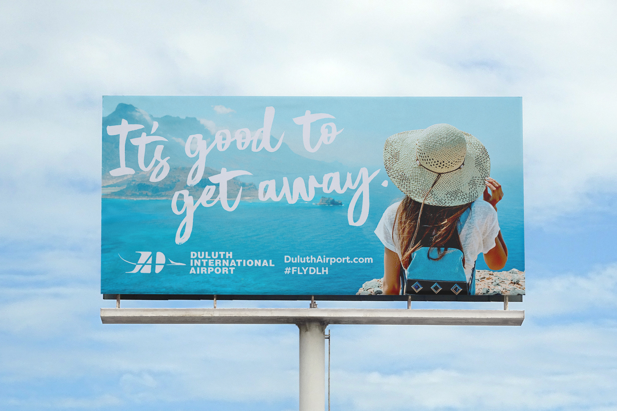 Billboard with woman in a sun hat looking at the ocean.
